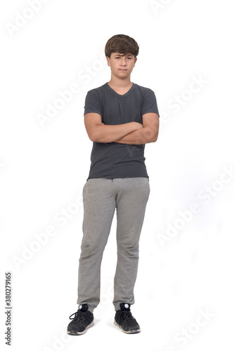 full portrait of a teenage boy dressed in sportswear on white background, front view and arms crossed and anger expression
