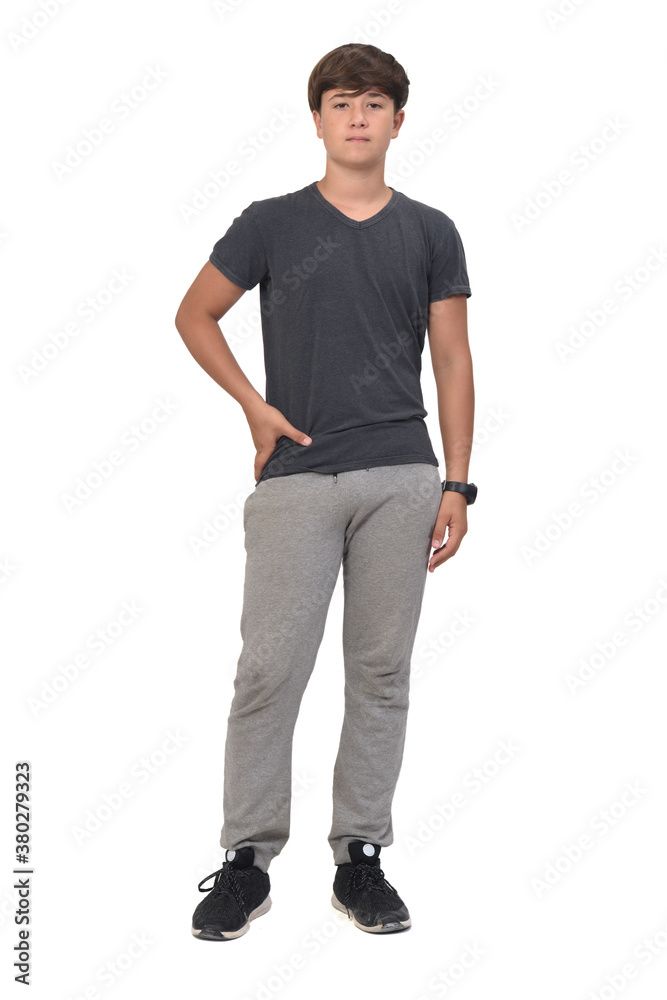 Fototapeta premium full portrait of a teenage boy dressed in sportswear on white background, front view and hands on hip