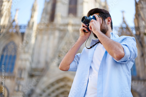Stylish man photographing town while traveling