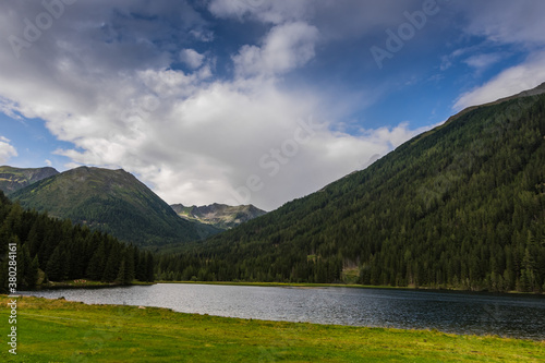 mountain lake with green meadow while hiking
