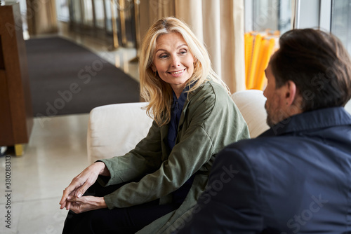 Mirthful woman smiling to her husband while sitting indoors