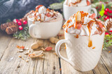 Salted Peanut Caramel Hot Chocolate. Keto and vegan hot chocolate recipe, with marshmallow and whipped coconut cream, wooden background with christmas winted decoration