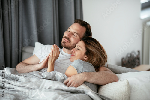 Young loving couple in bed. Happy couple relaxing in bed..