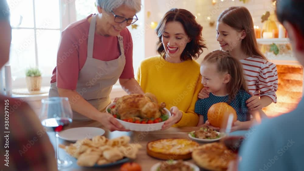 Happy Thanksgiving Day! Autumn feast. Family sitting at the table and celebrating holiday. Grandparents, mother, father and children. Traditional dinner.