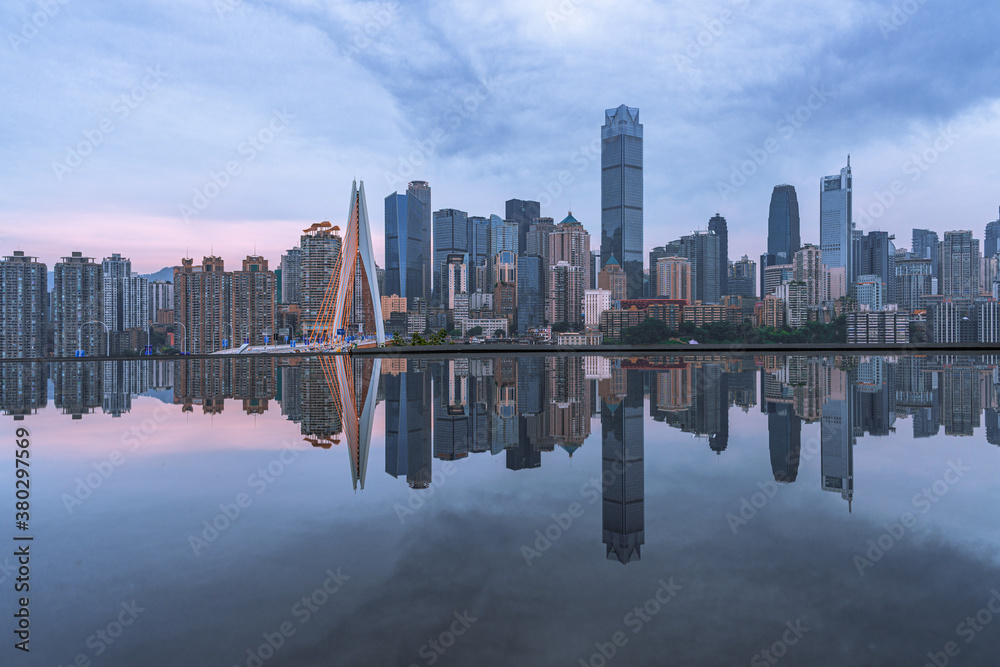 The skyline of downtown Chongqing on a cloudy day, with reflection in front.