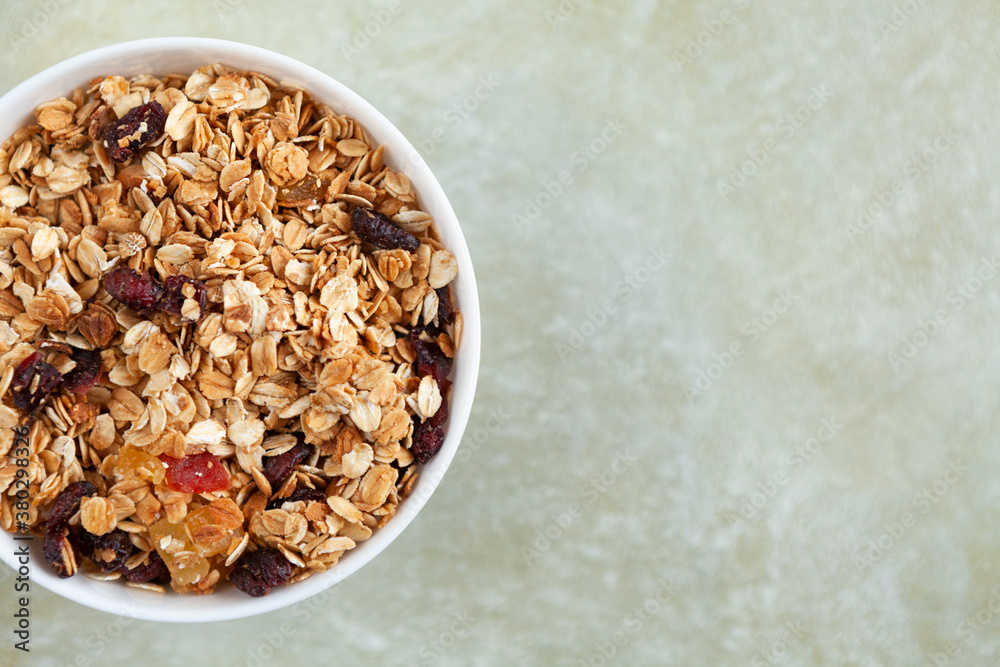 Plate with delicious homemade granola on a textured beige background, with a place for text, top view. Plate with delicious homemade granola on a textured beige background, with a place for text, top view.