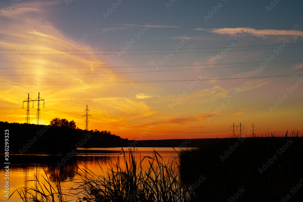 Sunset over a wide lake. Lake and forest on the far shore during sunset