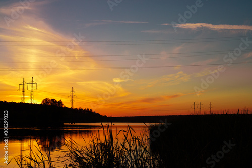 Sunset over a wide lake. Lake and forest on the far shore during sunset