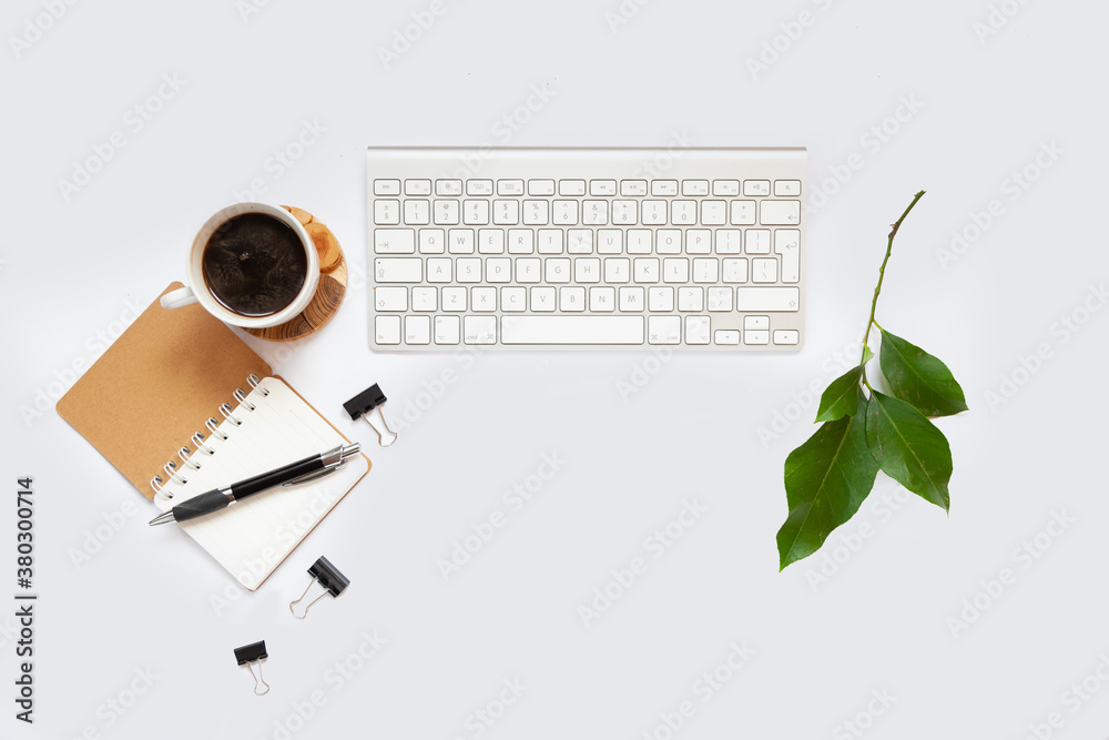 Office table top. Workspace with blank board with clip, keyboard, stationery, pencil, coffee cups on light gray background. Place for text Office table top. Workspace with blank board with clip, keyboard, stationery, pencil, coffee cups on light gray background. Place for text