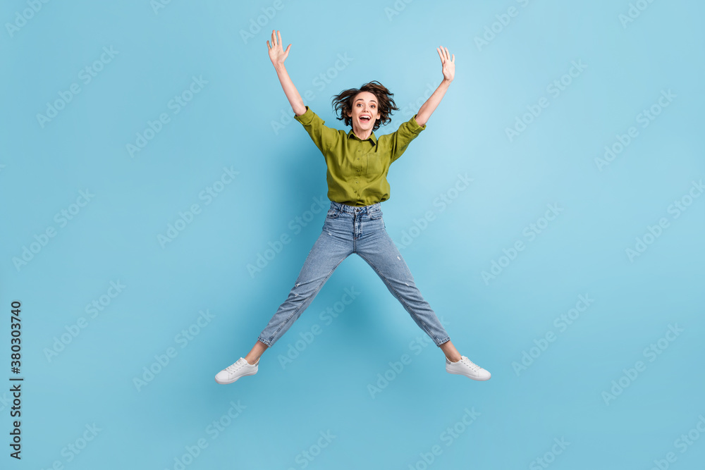 Photo portrait of young brunette girl jumping up spreading legs arms like star isolated on pastel light blue colored background