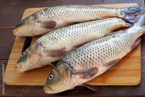 Three carps on a wooden cutting board