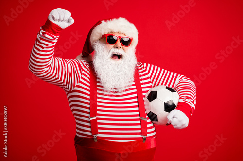 Portrait of his he nice handsome attractive cheerful cheery glad fat overweight Santa grandfather playing football having fun isolated over bright vivid shine vibrant red color background © deagreez