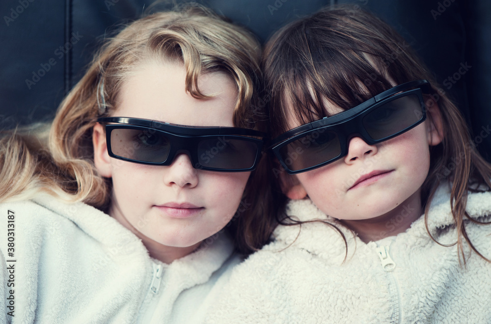 Sisters watching TV with their 3D glasses on Sisters watching TV with their 3D glasses on