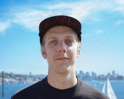 young man stares into the camera while standing outside the city photo