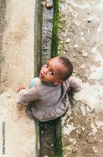 African baby sitting down looking to the camera. From above. Mizan, Ethiopia photo