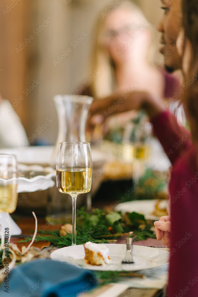 Friends laughing and having a good time around the table while enjoying Thanksgiving dinner Friends laughing and having a good time around the table while enjoying Thanksgiving dinner