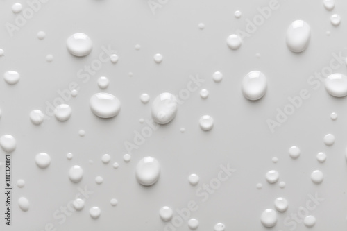Full background of water droplets, moisture or condensation on a white background. Liquid drops on bathroom tile or smooth surface.