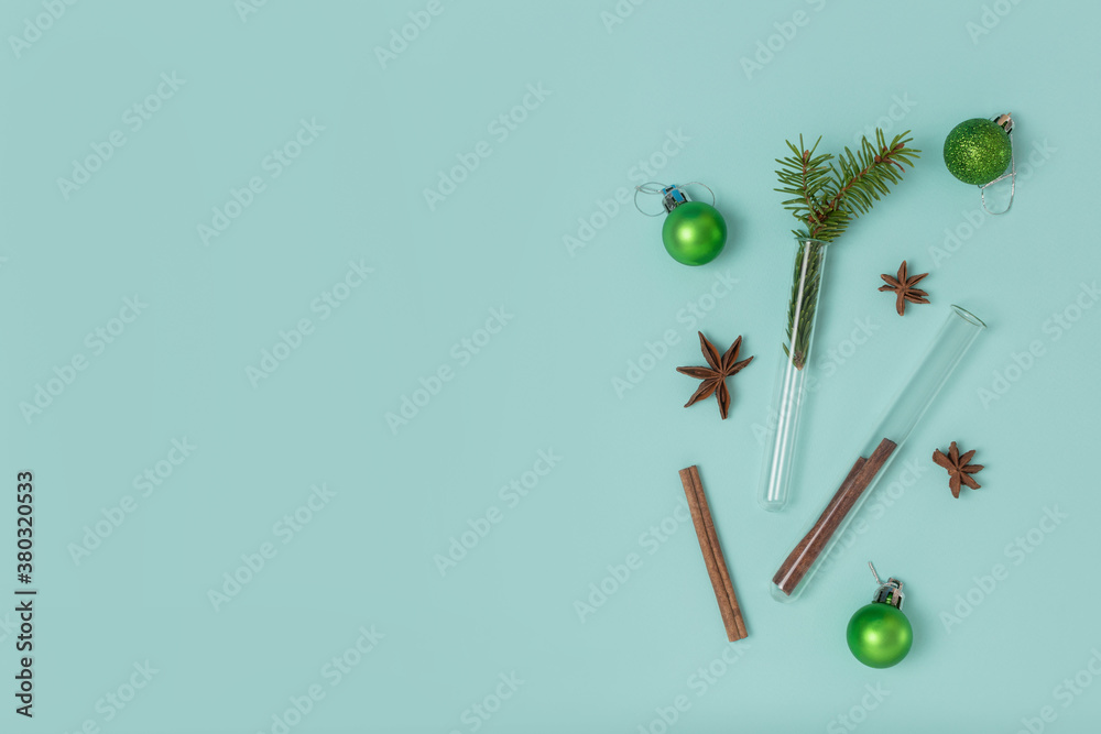Christmas composition of test tubes, festive balls, cinnamon and star anise on a mint background with copy space. Top view, flat lay. Medical New Year concept. Christmas composition of test tubes, festive balls, cinnamon and star anise on a mint background with copy space. Top view, flat lay. Medical New Year concept.
