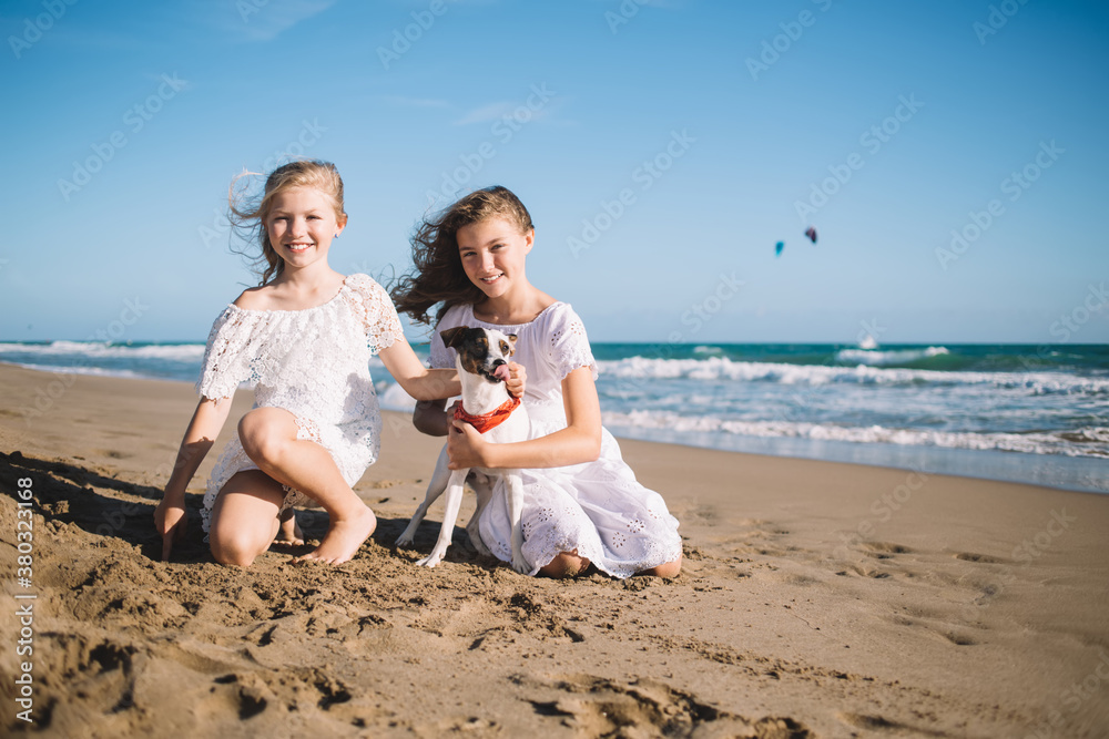 Cheerful girls with dog resting on beach Cheerful girls with dog resting on beach
