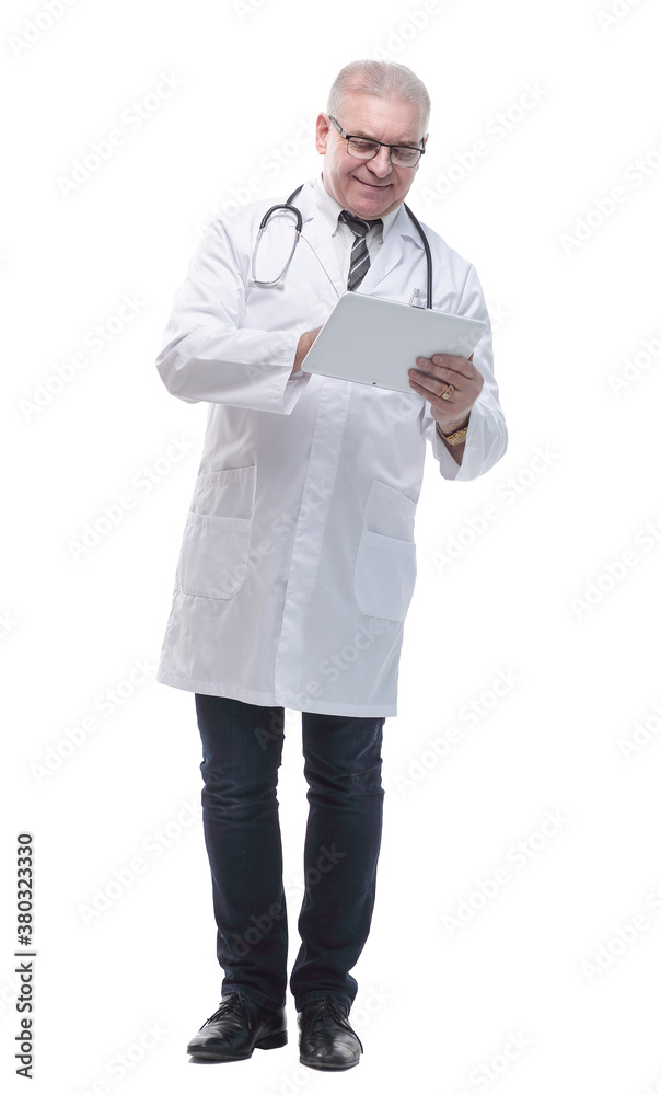 in full growth. smiling doctor looking at the screen of a digital tablet in full growth. smiling doctor looking at the screen of a digital tablet
