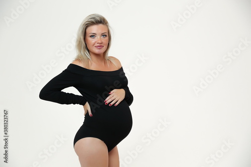 pregnant woman in black bodysuit on white background
