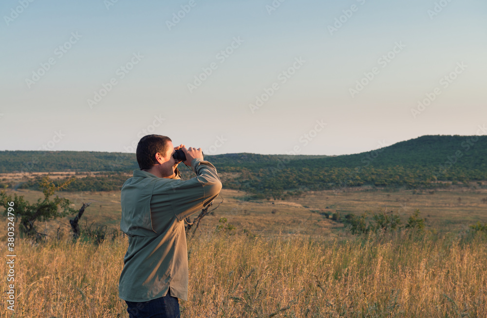 man on safari in South Africa, using binoculars to spot game man on safari in South Africa, using binoculars to spot game