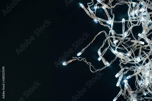 Christmas garland with lights on a black background.