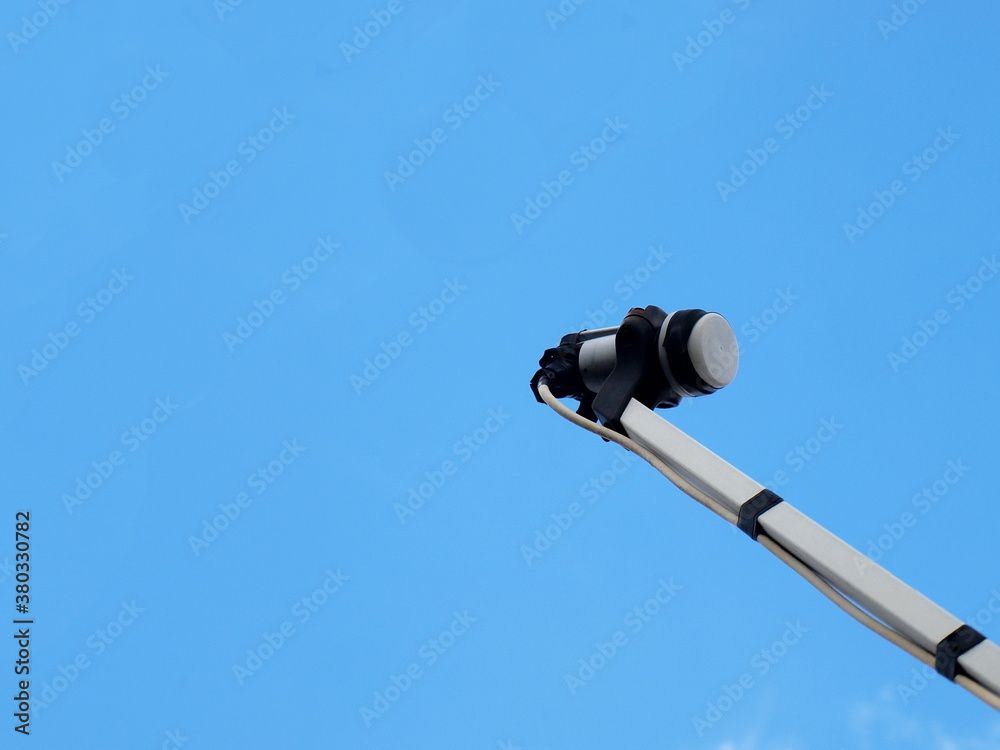 LNB or satellite TV receiver. Digital wave reception system (KU-Band universal) of a satellite dish. On a bright blue sky background with copy space. Focus close and choose the subject. LNB or satellite TV receiver. Digital wave reception system (KU-Band universal) of a satellite dish. On a bright blue sky background with copy space. Focus close and choose the subject.