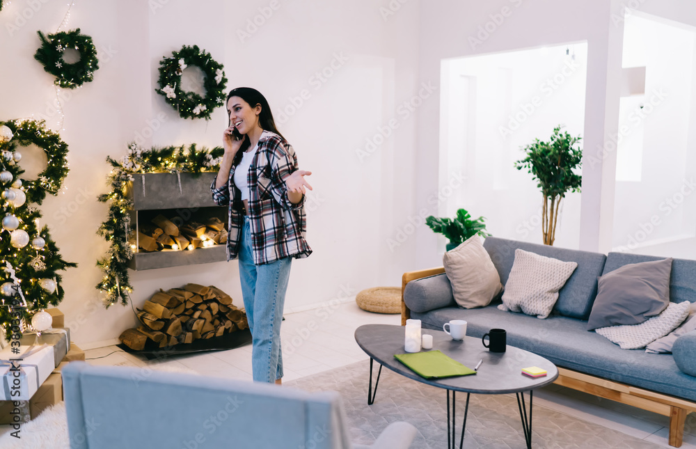 Happy lady having conversation on phone in living room