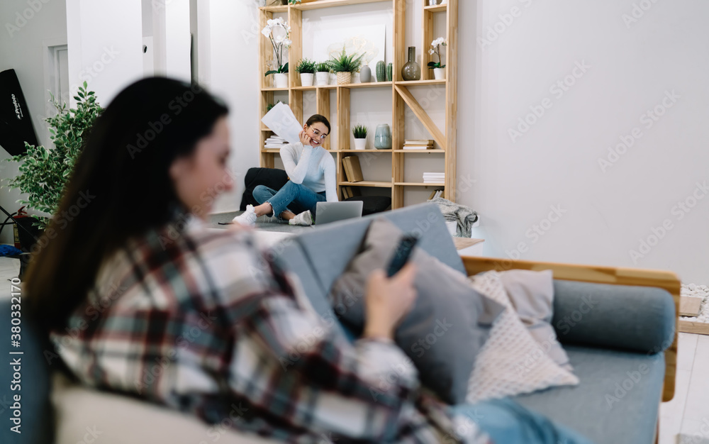 Positive woman browsing laptop at home Positive woman browsing laptop at home