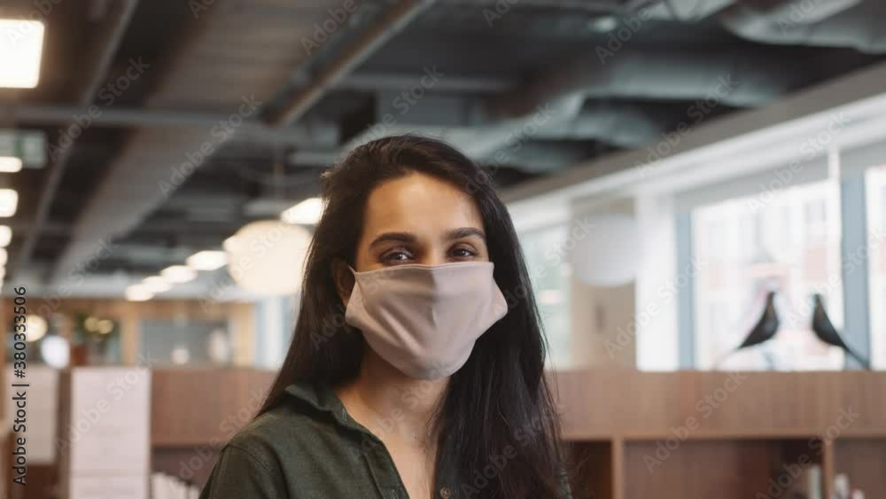 Portrait Of Businesswoman Wearing Face Mask In Modern Open Plan Office During Covid-19 Pandemic Portrait Of Businesswoman Wearing Face Mask In Modern Open Plan Office During Covid-19 Pandemic