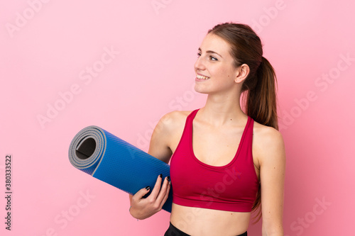 Young sport woman over isolated pink background