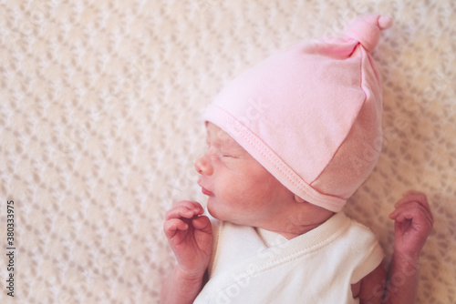 Newborn baby girl wearing a pink beanie viewed from above photo