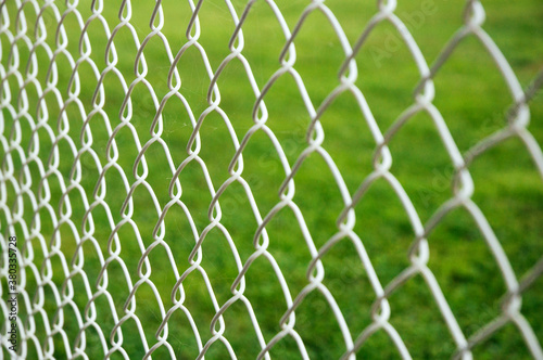 White wired fence in front of green grass
