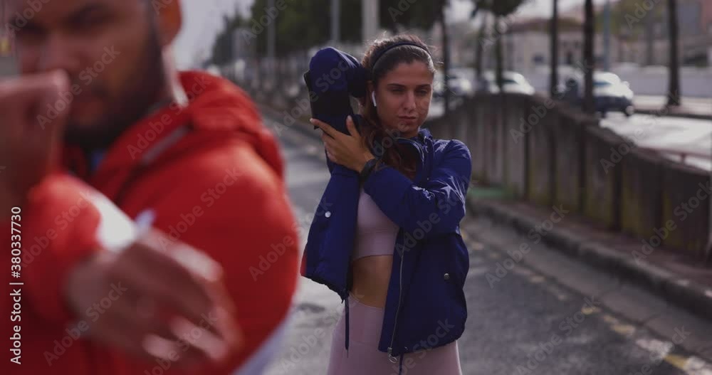 Active woman and man stretching together in urban city Active woman and man stretching together in urban city