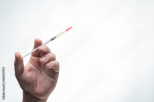Mano caucasica sosteniendo vacuna de coronavirus covid-19 con fondo blanco en argentina