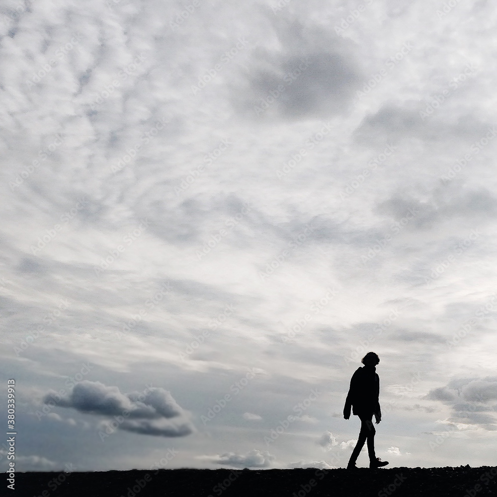 Silhouette of a girl with clouds behind her Silhouette of a girl with clouds behind her