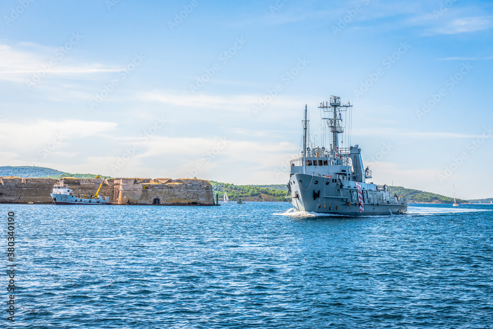 Warship entering the bay past the medieval fortress near the town of Sibenik in Croatia