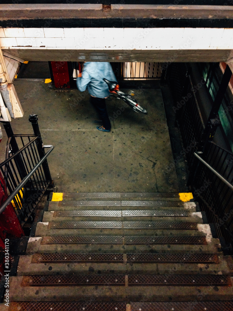 Man Carrying Bicycle into Manhatten Subway Station Man Carrying Bicycle into Manhatten Subway Station
