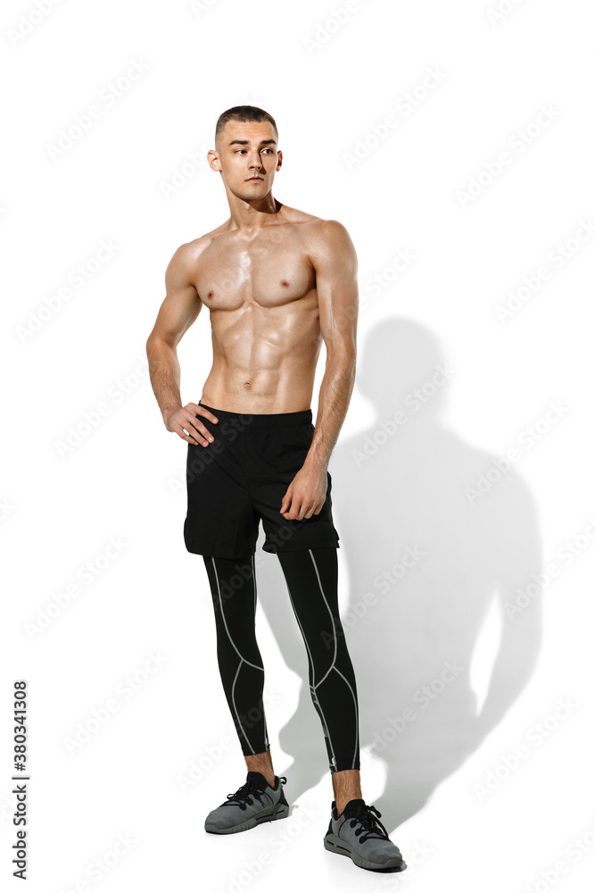 Posing. Stylish young male athlete practicing on white studio background, portrait with shadows. Sportive fit model in works out in motion and action. Body building, healthy lifestyle, style concept. Posing. Stylish young male athlete practicing on white studio background, portrait with shadows. Sportive fit model in works out in motion and action. Body building, healthy lifestyle, style concept.