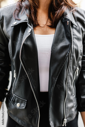 Closeup of woman wearing leather jacket and long black skirt.