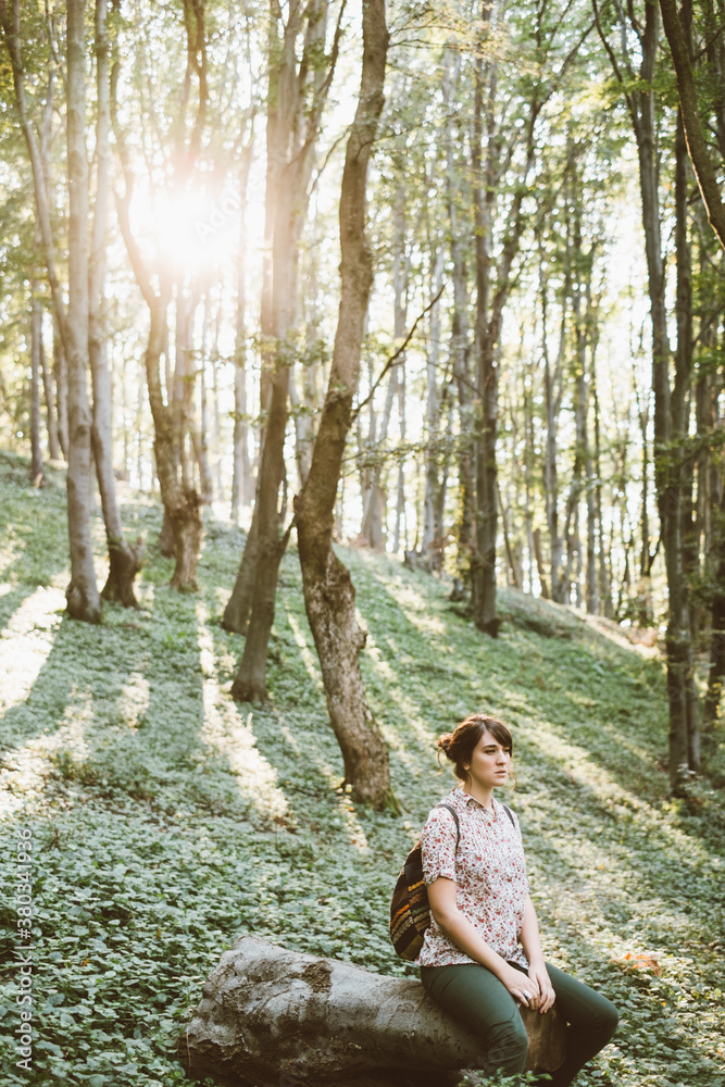 Young woman sitting in the forest alone Young woman sitting in the forest alone