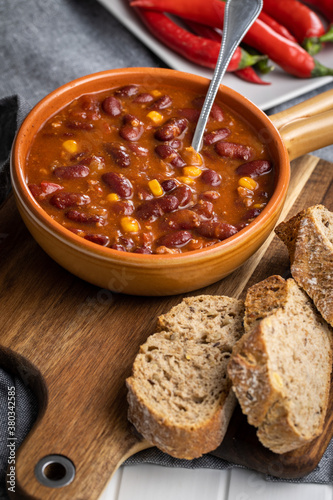 Chili con carne. Mexican food with beans in pot and bread