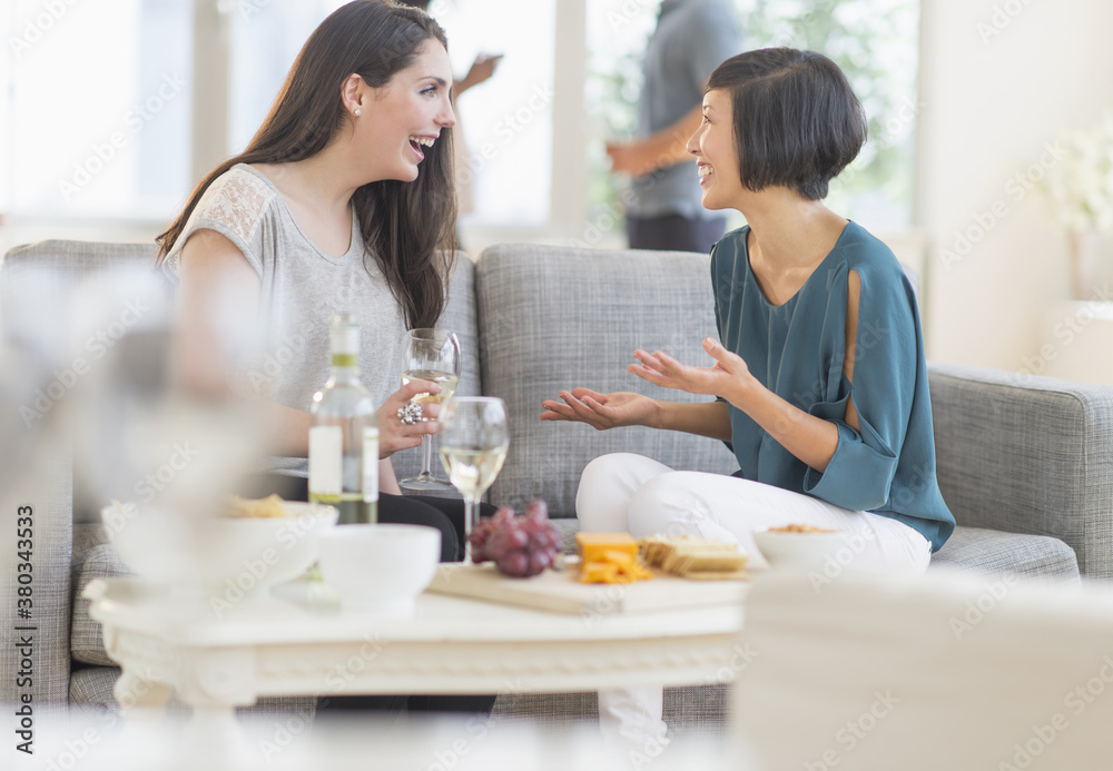 Two friends sitting on sofa and talking Two friends sitting on sofa and talking