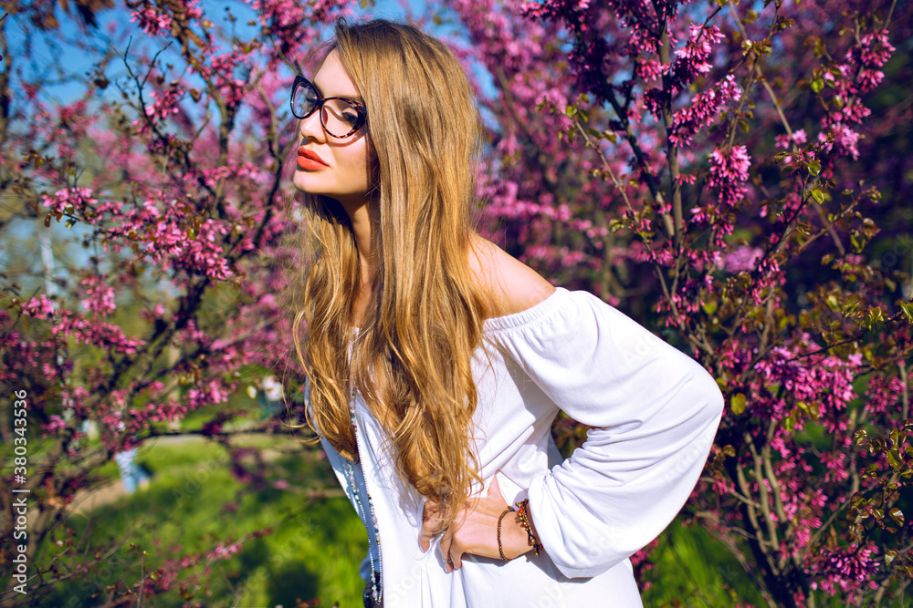 Close up spring summer portrait of stunning young woman with natural amazing long hairs and beauty face, wearing clear glasses and looking on camera, sunny colors. Close up spring summer portrait of stunning young woman with natural amazing long hairs and beauty face, wearing clear glasses and looking on camera, sunny colors.