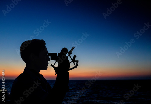 Man looking through sextant photo