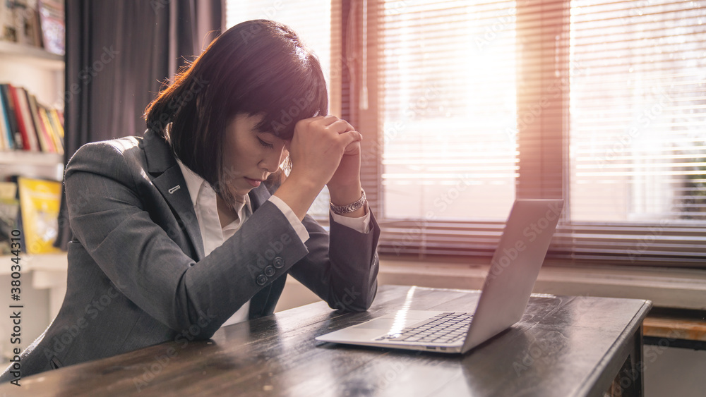 Business women in suits are working with high stress At the work desk there is a labtop. Concept of working with stress Business women in suits are working with high stress At the work desk there is a labtop. Concept of working with stress