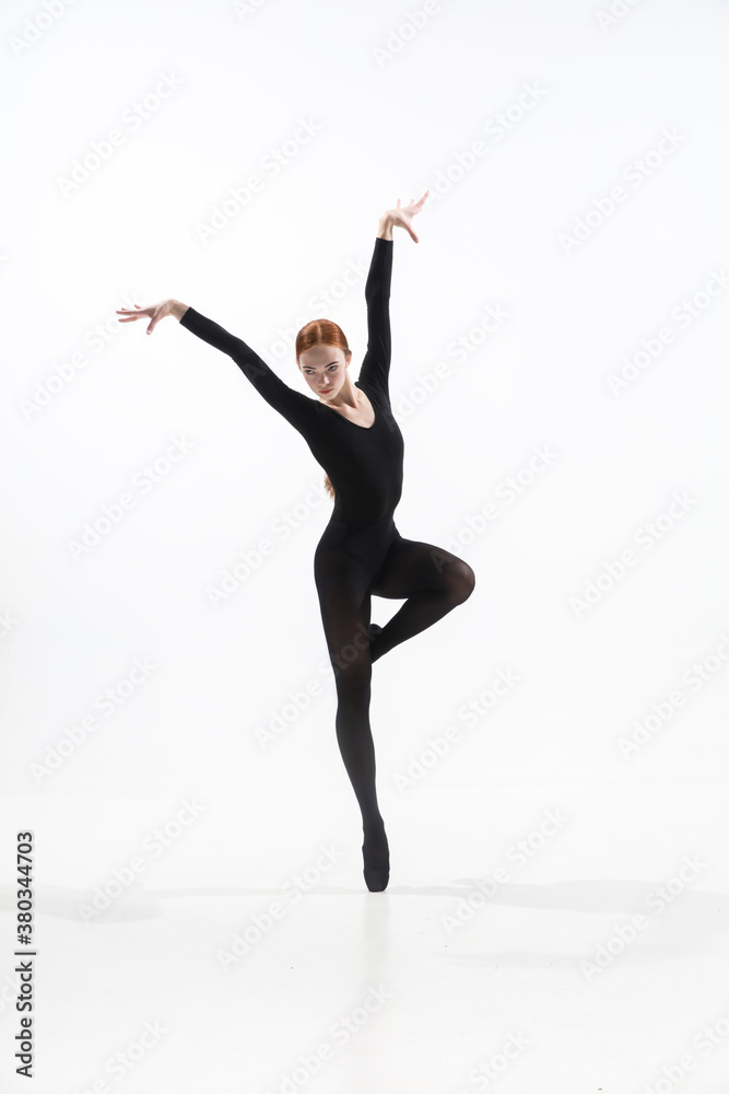 Black bird. Young and graceful ballet dancer in minimal black style isolated on white studio background. Art, motion, action, flexibility, inspiration concept. Flexible caucasian ballet dancer.