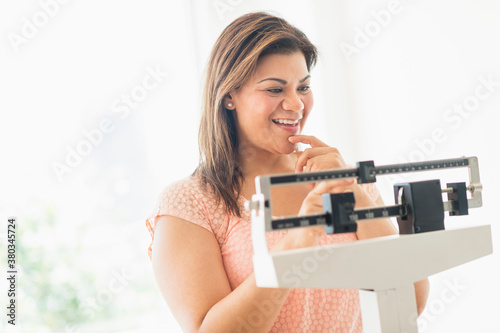 Happy woman standing on scale