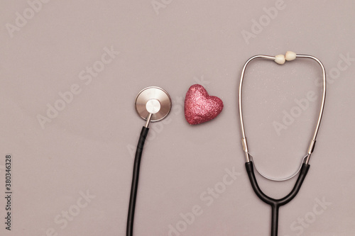 Stethoscope with red heart on wooden table